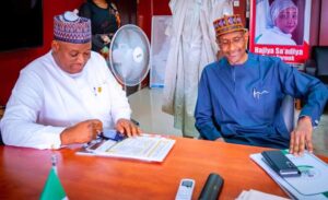 The new Permanent Secretary, Alhaji Nasir Sani Gwarzo (l), going through some notes just as his predecessor, Malam Bashir Nura Alkali, looks on with interest