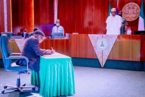 Justice Olukayode Ariwoola signing the oath as President Buhari watches with interest (Photo: State House)